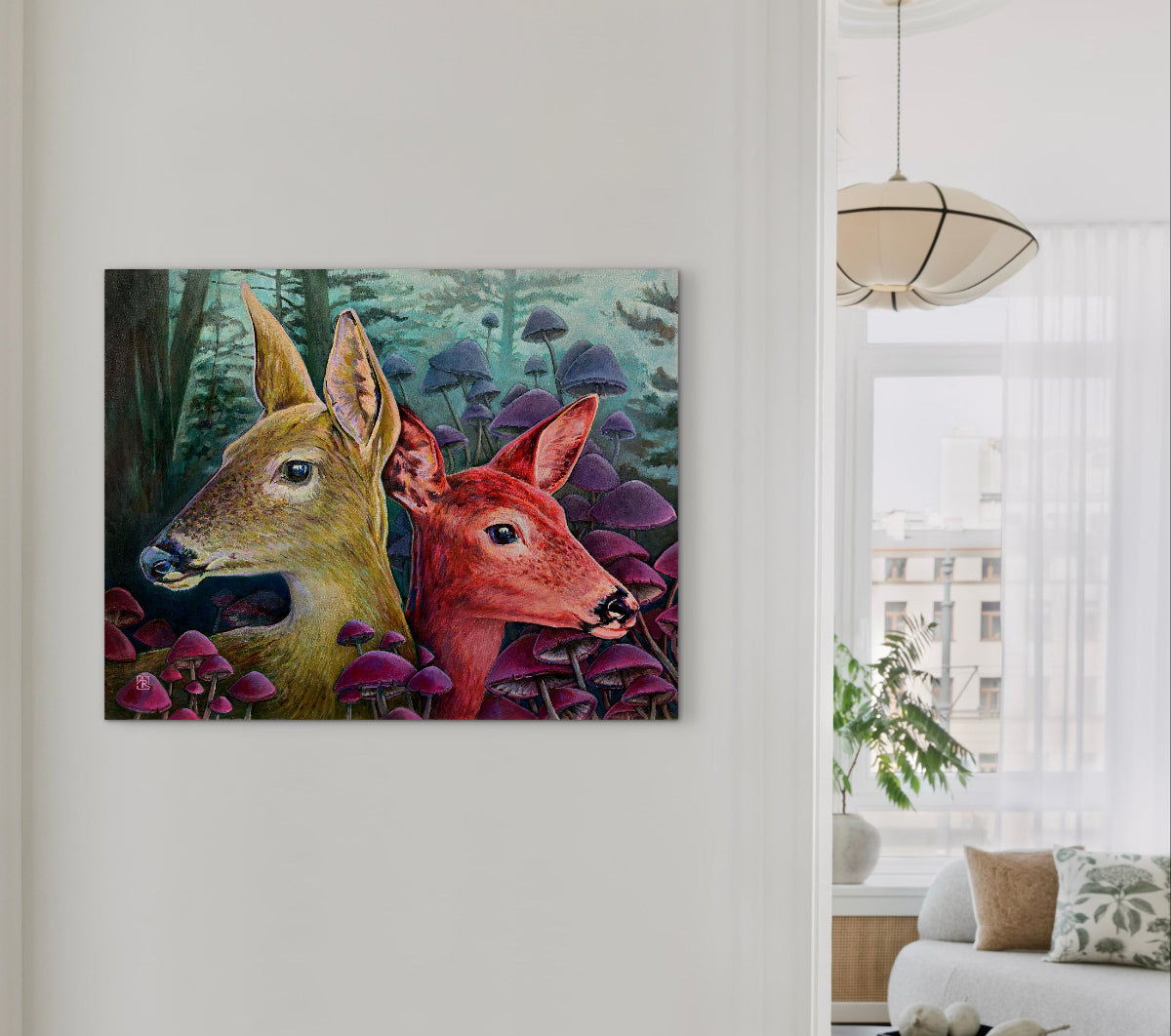 Framed artwork of two deer in a forest scene on a wall in a living room.