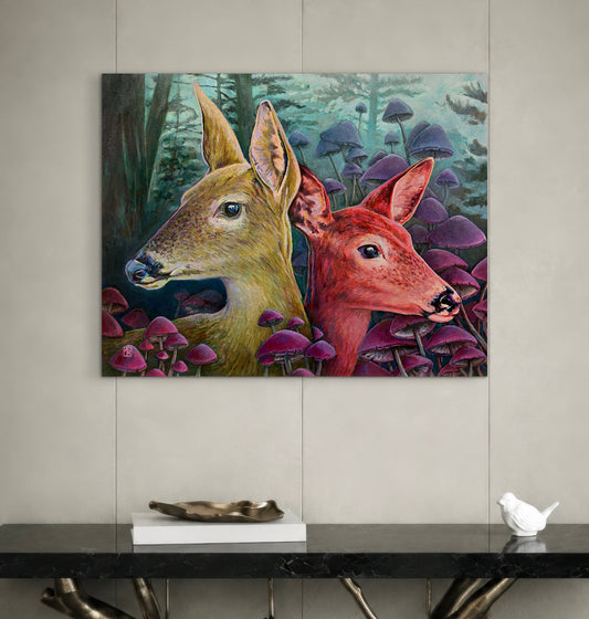 Framed artwork of two deer in a forest with mushrooms on a wall above a console table.
