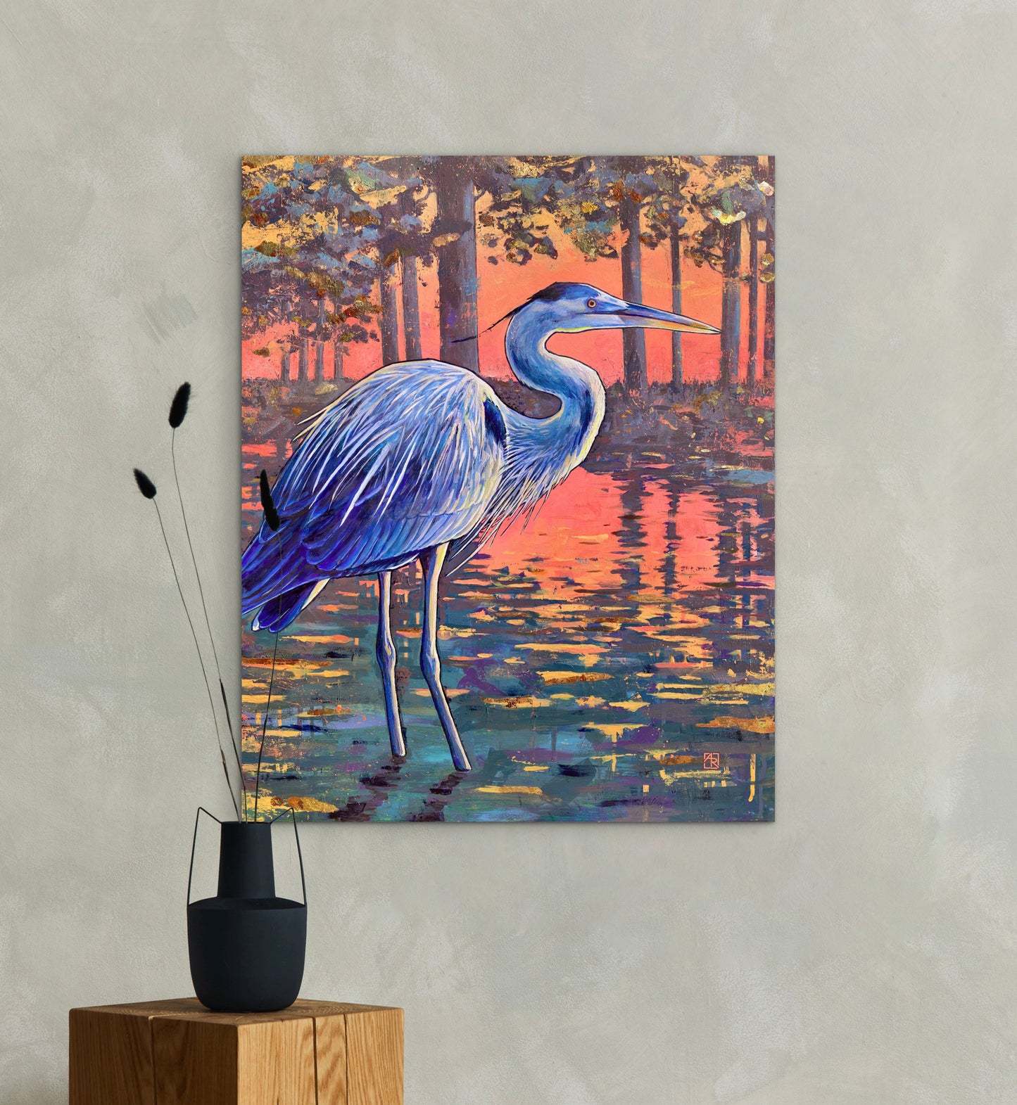 Painting of a blue heron in a natural setting on a wall above wooden stands with decorative items.