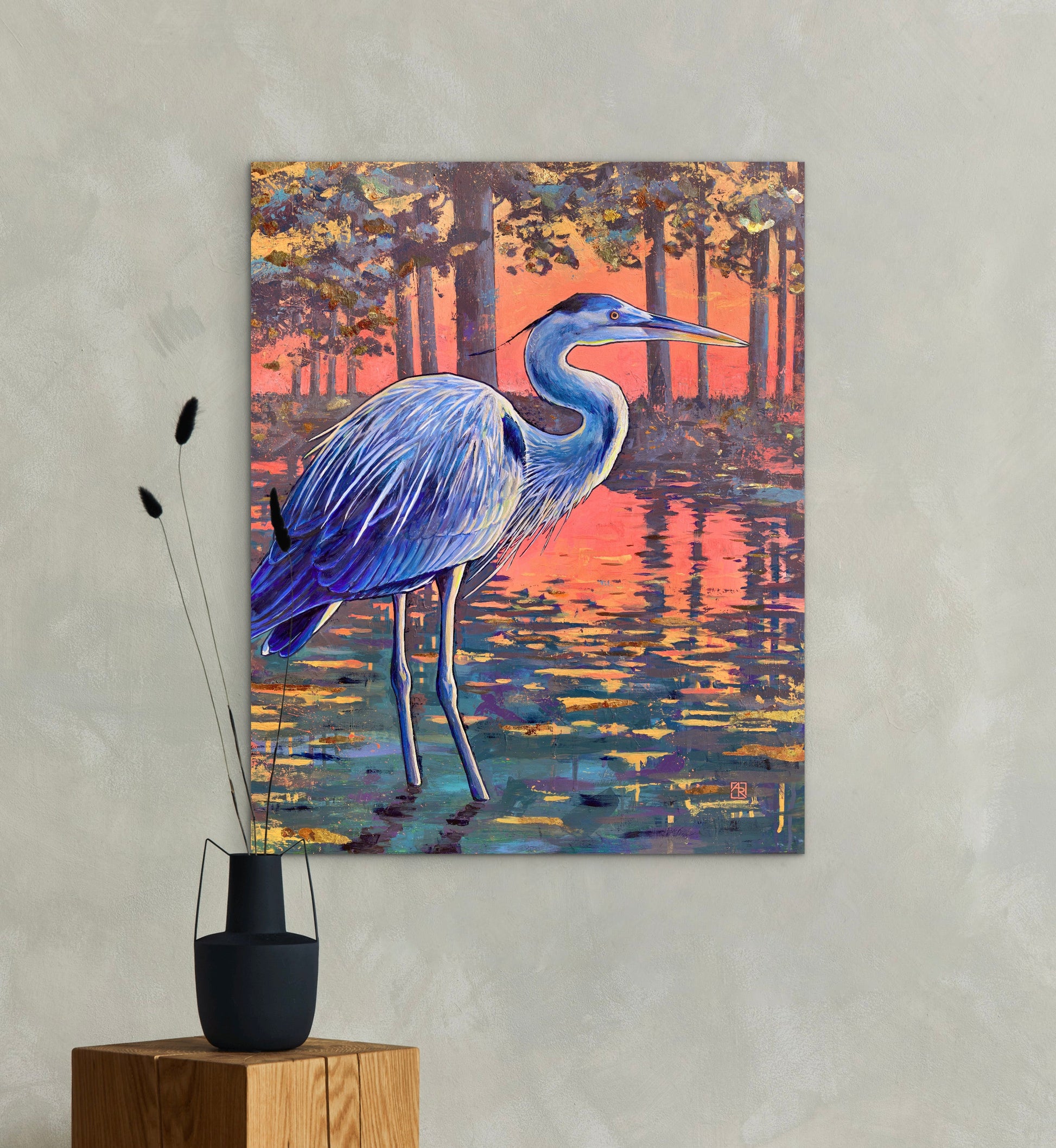 Painting of a blue heron in a natural setting on a wall above wooden stands with decorative items.